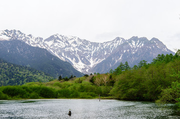 Hotaka mountain range and taisho ike pond in spring at kamikochi national park nagano japan