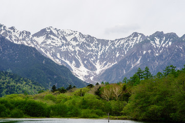 Hotaka mountain range and taisho ike pond in spring at kamikochi national park nagano japan
