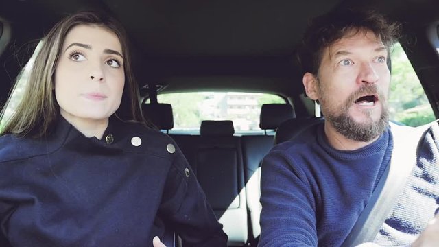 Man pulling long hair of girlfriend screaming and shouting angry driving car closeup slow motion