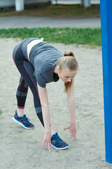 A sweet girl is doing exercises. A young girl kneads in the morning on the street. Healthy lifestyle.