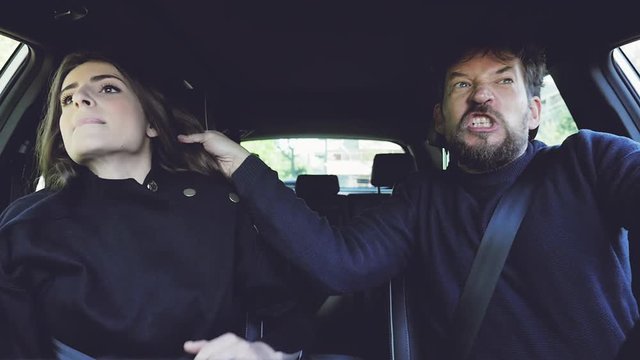 Man pulling long hair of girlfriend screaming and shouting angry driving car