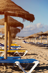 Beach chairs and umbrellas arranged in a line on the sands of Lagos, Portugal