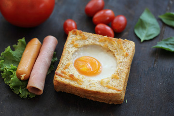 Egg in bread on wooden background