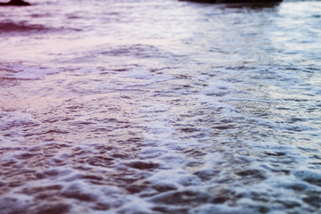 Sea foam rolling in over a rocky beach in Lagos, Portugal