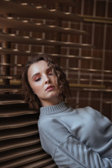 Fototapeta premium Young woman leaning against art sculpture
