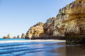 A view of the tide coming in from the rocky beach in Lagos, Portugal during sunset