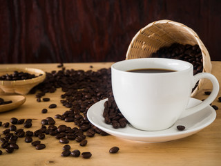 coffee cup and coffee beans in basket weave on wood table