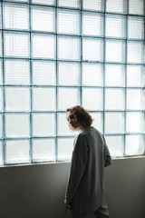 Fototapeta premium Young woman standing near window