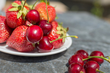 red strawberries and cherries on plate