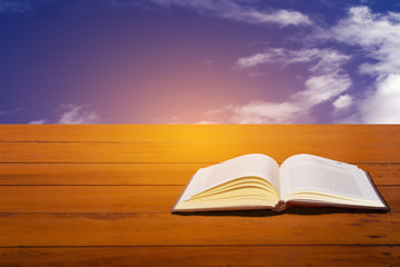 Books on a wooden desk on a sky background