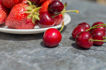 red strawberries and cherries on plate