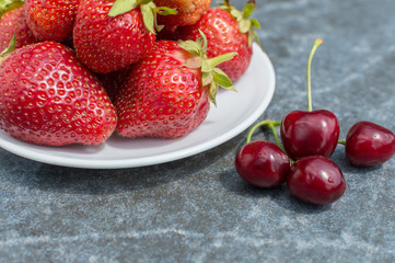 red strawberries and cherries on plate