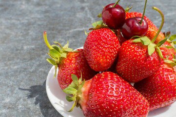 red strawberries and cherries on plate