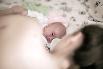 Newborn baby in mother embrace	