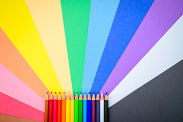 Colorful pencils on colorful paper background