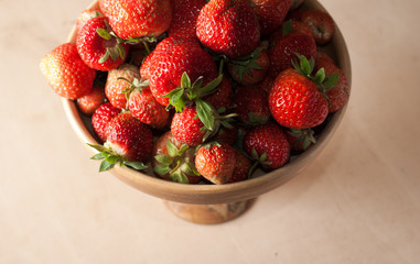 Fresh strawberries in wooden kitchenware, wooden background,