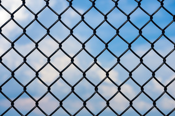 black chain link fence with summer sky background