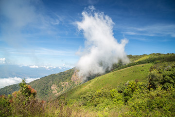 Fototapeta premium Scenery of green mountain with floating cloud on surface and blue sky in countryside of Thailand.