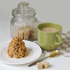 Coffee in a green mug and dessert from a shortbread in the form of a hill