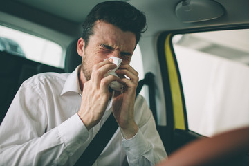 from a young man with handkerchief. Sick guy has runny nose. man makes a cure for the common cold...