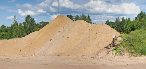 The high hill of the brought sand for construction in the wood.