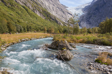 Fototapeta na wymiar Picturesque mountain valley with turbulent river and Briksdal glacier, Norway