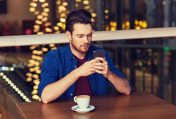 man with smartphone and coffee at restaurant