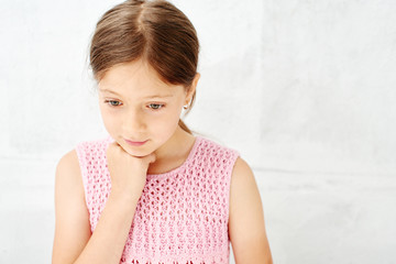 Portrait of a little girl on the white background of the wall