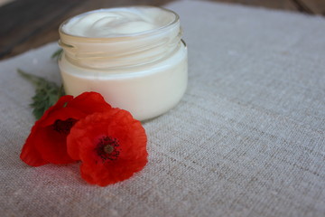 Fototapeta na wymiar Cosmetic cream with poppy flower
