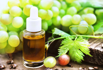 Grape seed oil on grape berries and leaves background