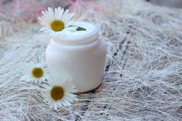 Fototapeta na wymiar Cosmetic cream with white camomile flower