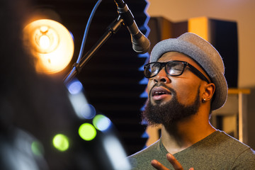 Black male singing in a recording studio, close up