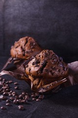 Two dark chocolate muffins with black background