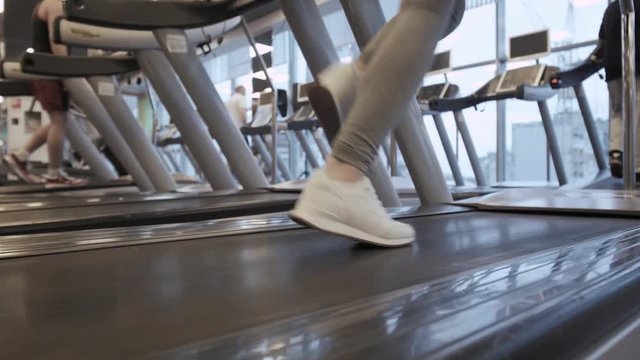 Detail of close up legs of woman running on treadmills gym
