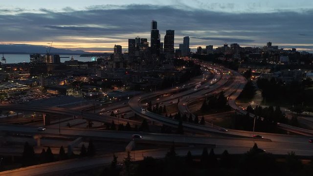 Night Aerial of Seattle with Glowing Lights from Skyscrapers in City Skyline and Freeway Cars