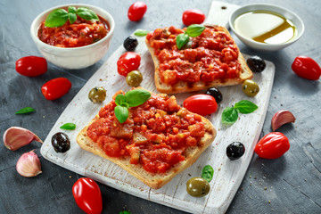 Fresh homemade crispy Italian appetizer Bruschetta topped with tomato, eggplant, Zucchini, Yellow pepper, garlic and basil on white wooden board. healthy food