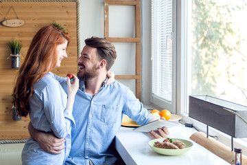 Young couple enjoy breakfast and using tablet.