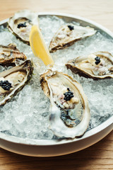 Raw and fresh Oyster with caviar on top and lemon © siraphol