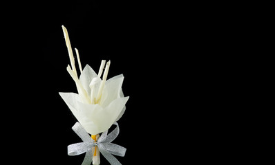 Kind of wood flower on black background with copy space; to be placed on the site of cremation in Thailand  (Dok Mai Jan)