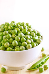 Peas in a bowl. Fresh and raw vegetable on a wooden table.