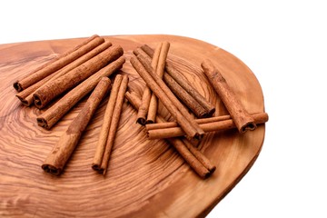 Cinnamon on wooden board isolated on white background