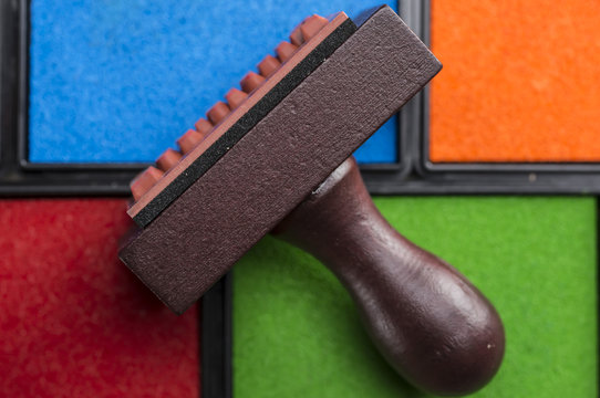 Close up shot of rubber stamp and multiple colors of ink boxes