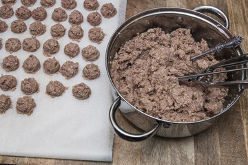Meatballs preparation with use ice cream scoop, on white marble cutting board, salt, pepper
