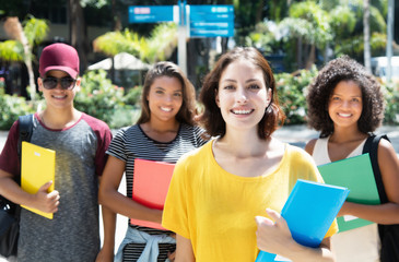Lachende deutsche Studentin mit anderen Stundenden in der Stadt
