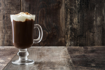 Irish coffee in glass on wooden background

