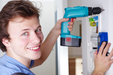 Ein Elektriker bei der Arbeit an einem Sicherungskasten