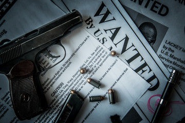 An announcement about the search for a criminal on the table of the bounty hunter, a combat pistol,...