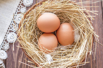 Chicken eggs in a basket with hay