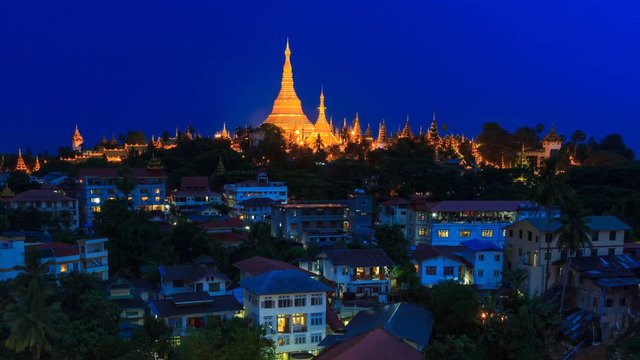 Shwedagon Pagoda Over Yangon Cityscape Of Myanmar 4K Day to Night Time Lapse (pan shot)