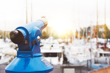 Touristic telescope look at the city with view of Barcelona Spain, close up old blue binoculars on background viewpoint  the pier port yacht, coin operated  in panorama observation nature, mockup